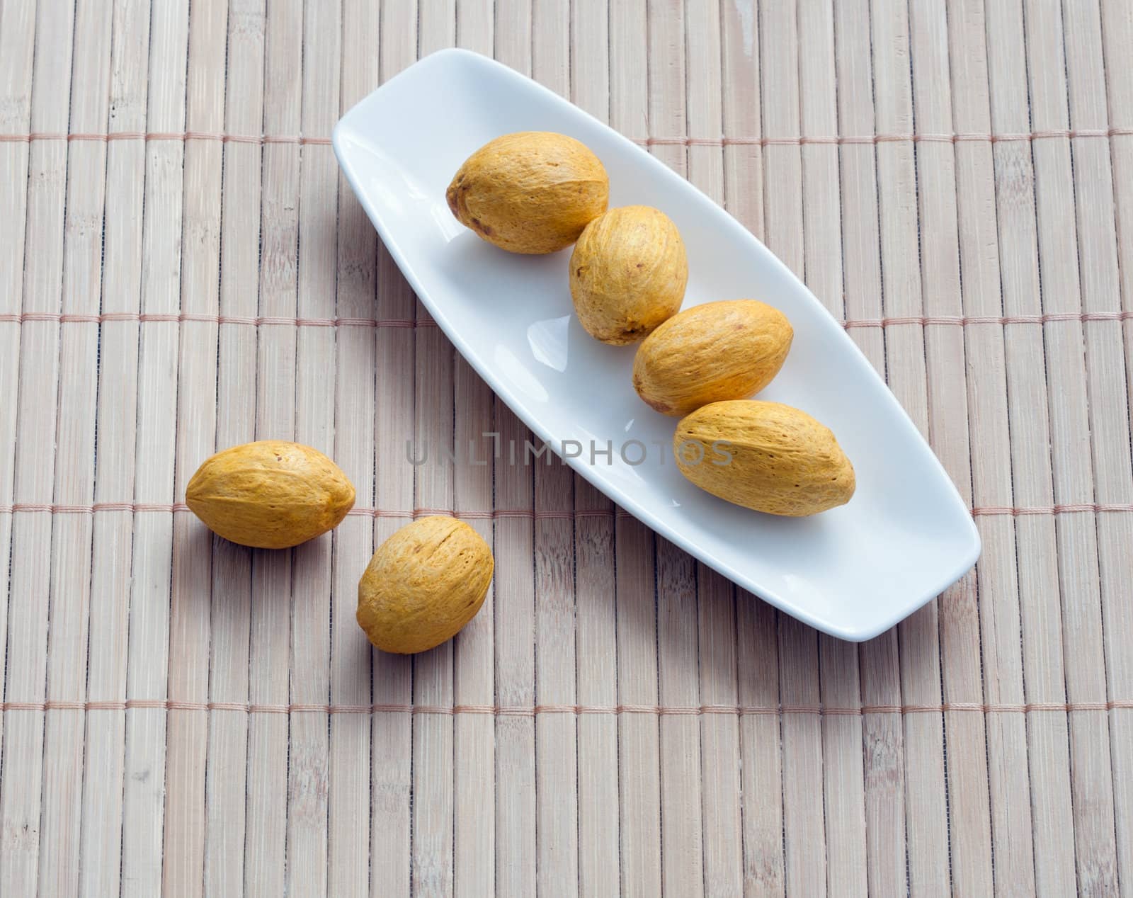 dish of nuts on a bamboo napkin by sfinks