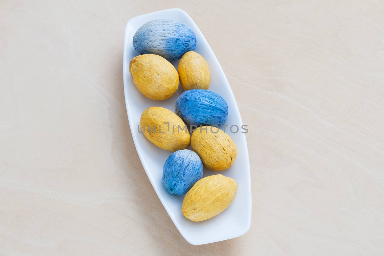 colorful decorative nuts on a plate by sfinks