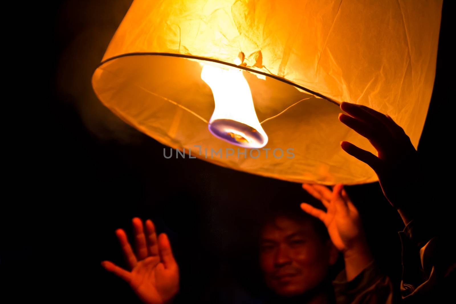 CHONBURI, THAILAND - NOVEMBER 28: Two people holding a flying fire lantern to celebrate the Loy Krathong festival. November 28, 2012 in Hua Hin, Thailand.