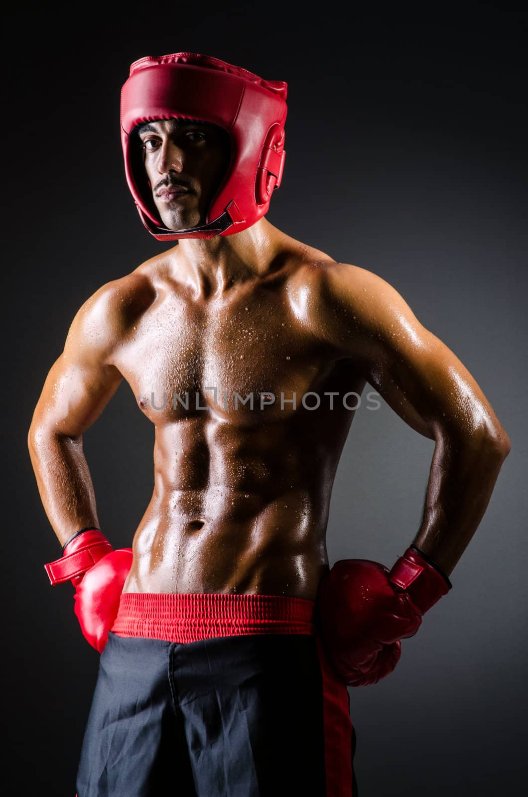 Muscular boxer in dark studio