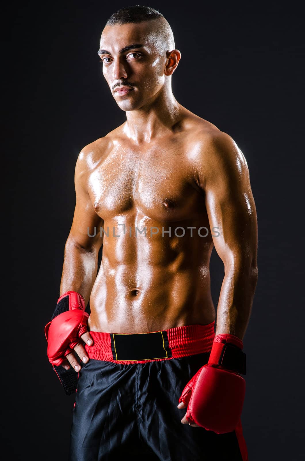 Boxer with red gloves in dark room