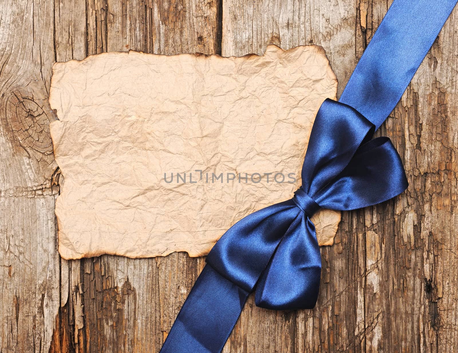 Blue bow on blank old paper with copyspace for your text by inxti