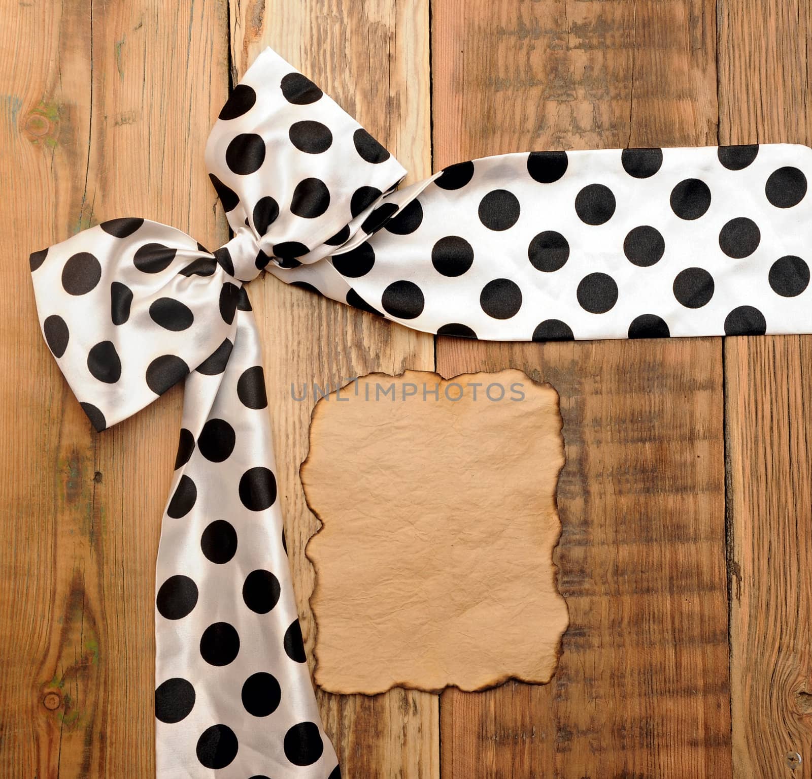 white bow with black dot on wooden background with copyspace for your text