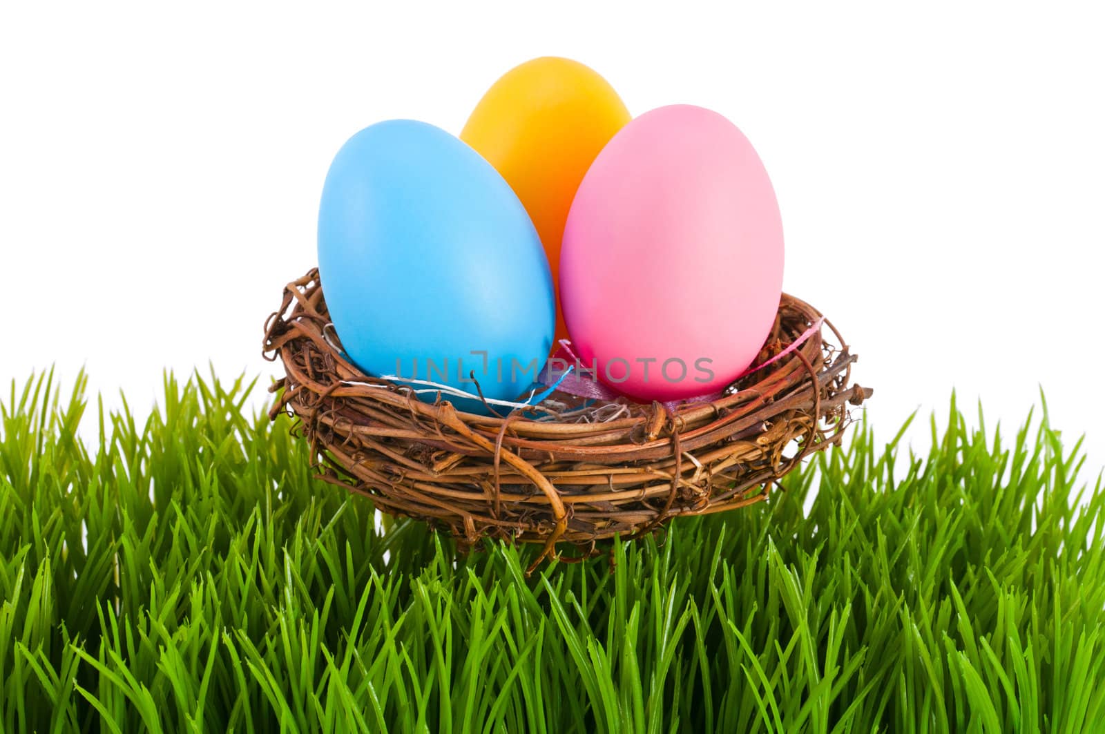 Colored Easter eggs in a nest on a white background.