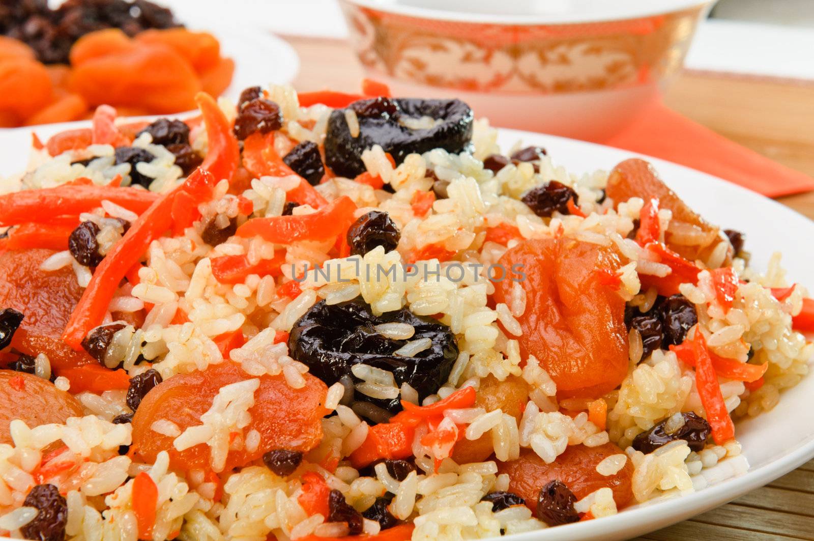 Pilaf made ​​of rice, fresh carrots and dried plums, grapes, apricots.
