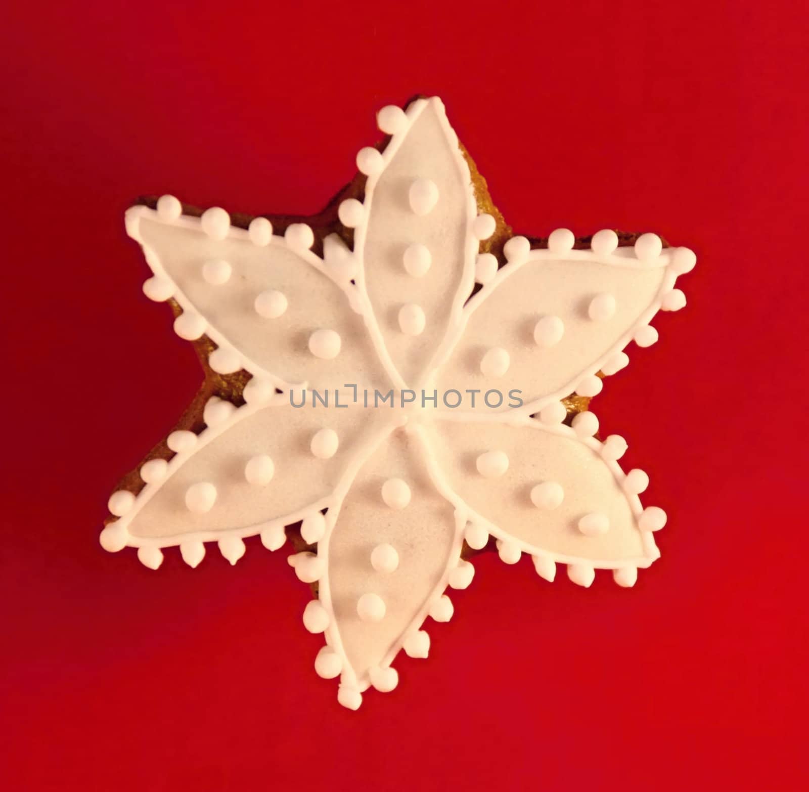 Christmas star made by gingerbread aranged on red background