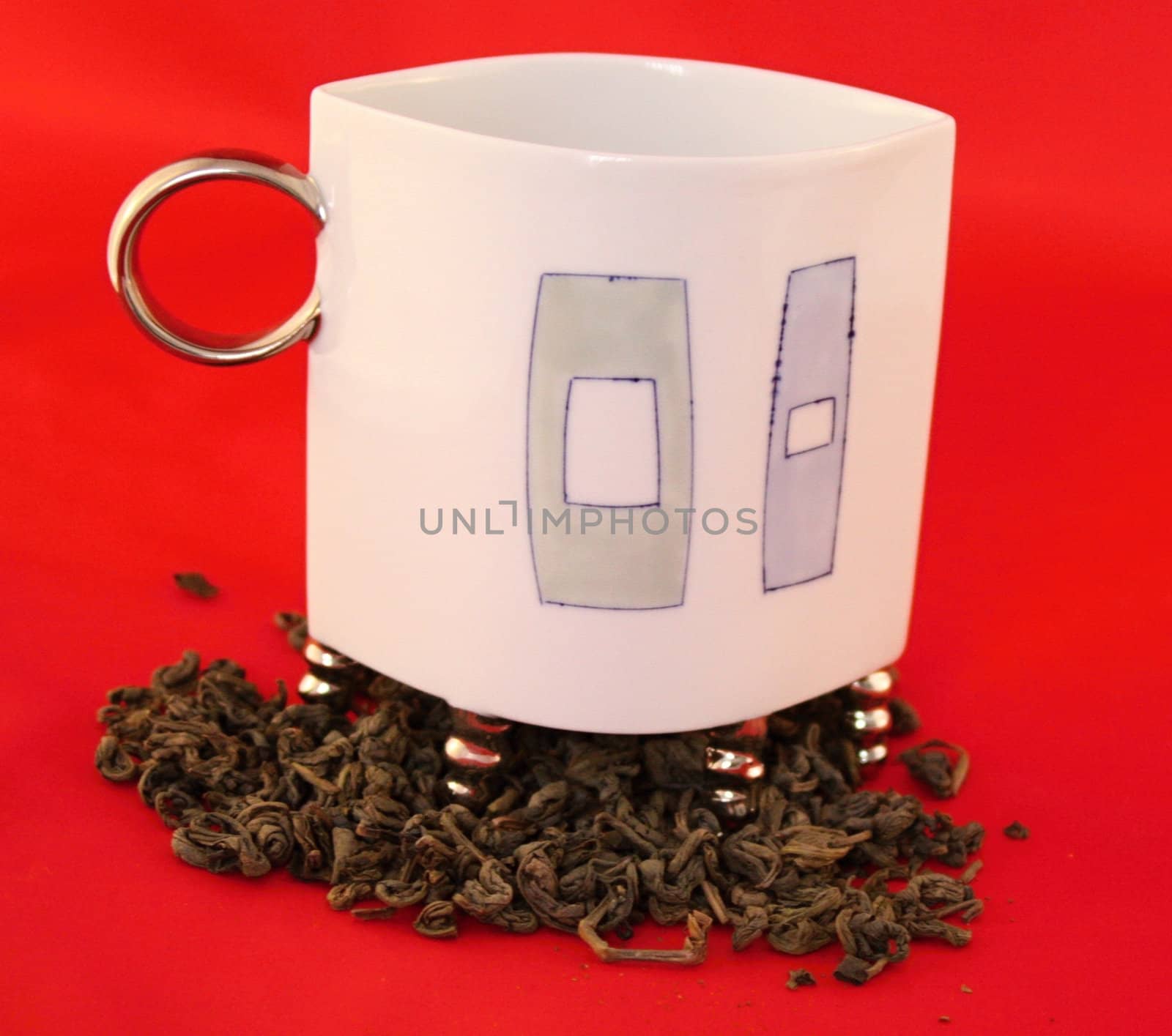Cup with leaf tea on red background