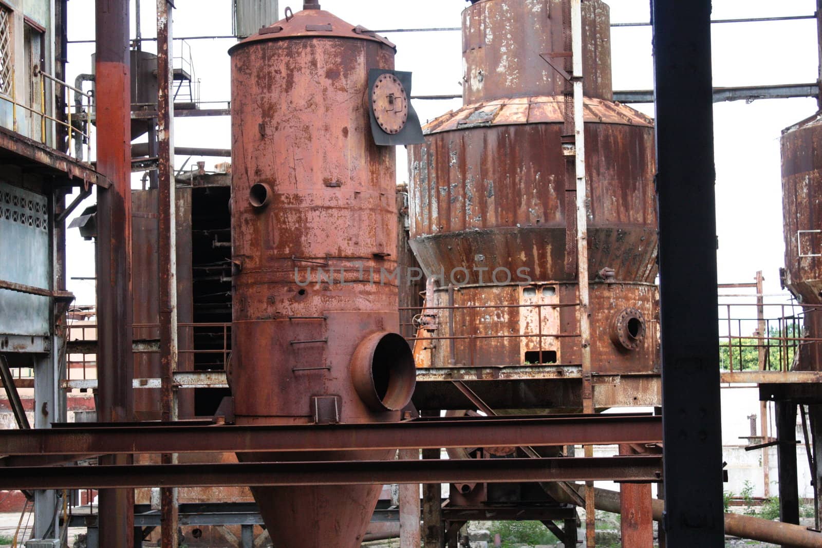 Rusty industrial tanks or vats in an abandoned factory.