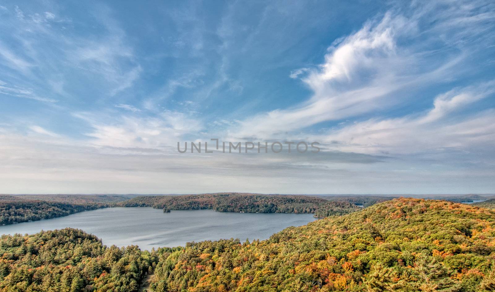 Lake Surrounded by Fall Trees and Whispy Clouds by JamesWheeler