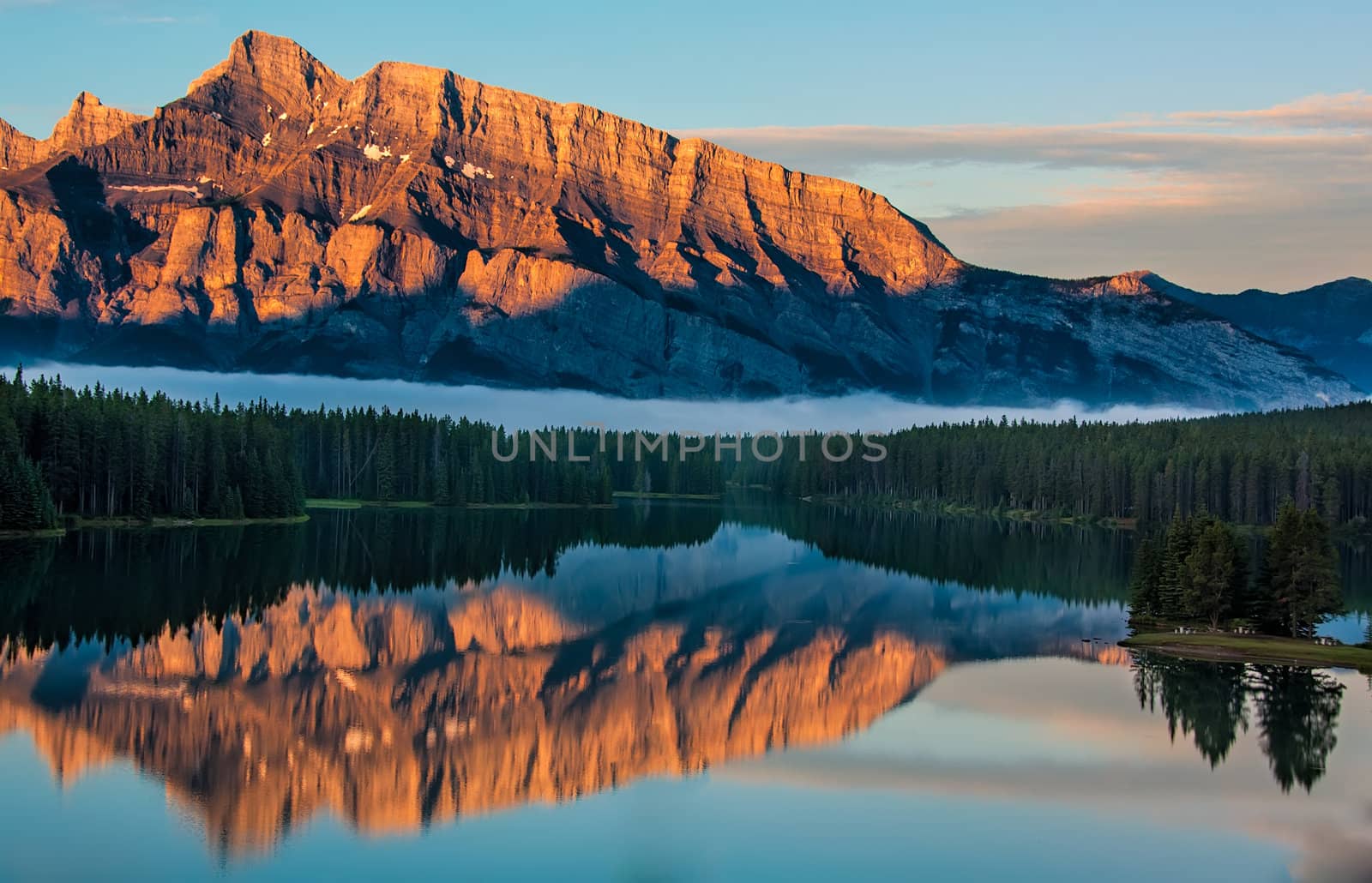 View across two jack lake from Lake Minnewanka Scenic Drive at sunrise in Banff National Park.