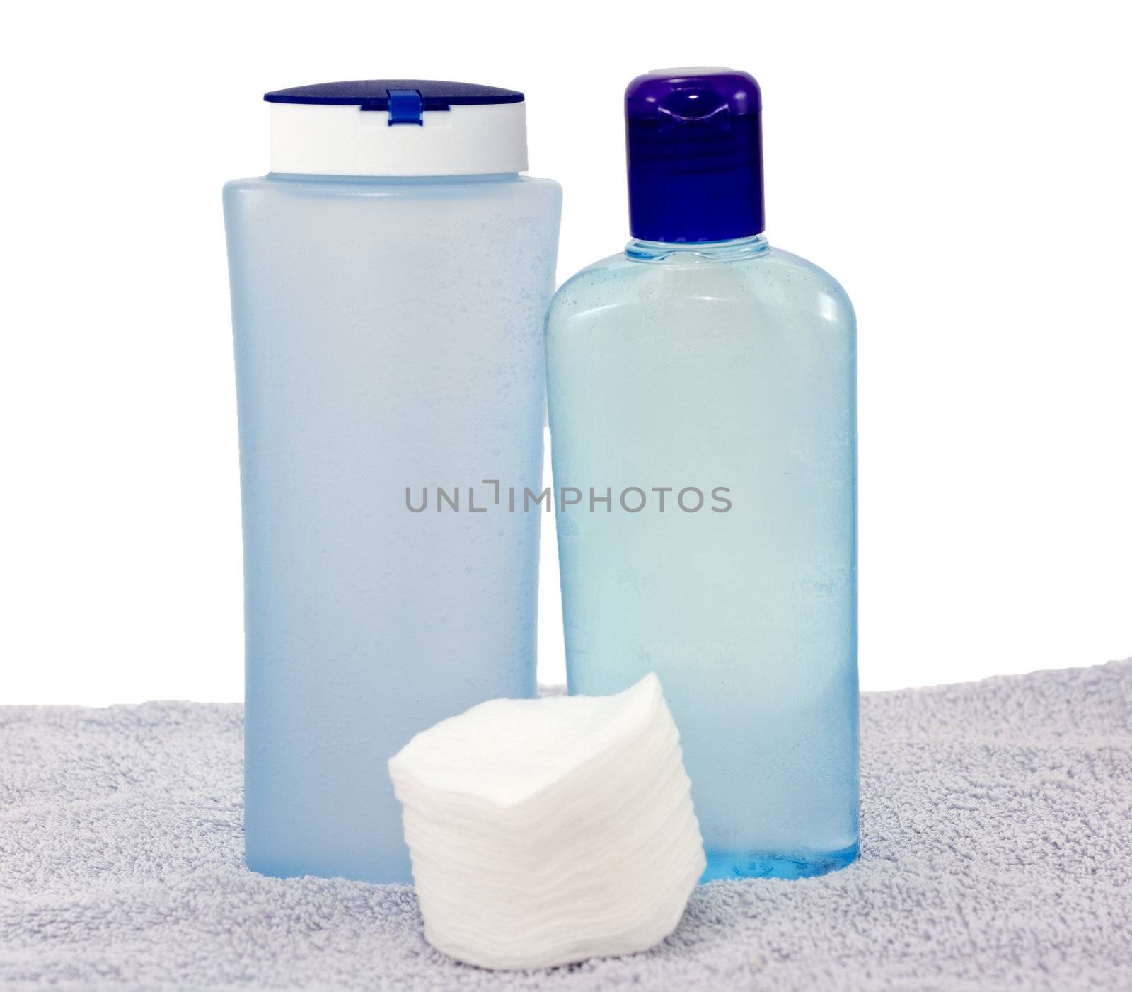 Lotions for the face and cotton pads on a towel