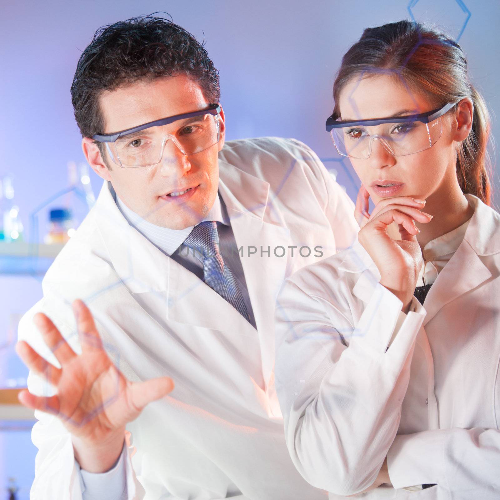 Portrait of a focused health care professionals in their working environment writing structural chemical formula on a glass board.