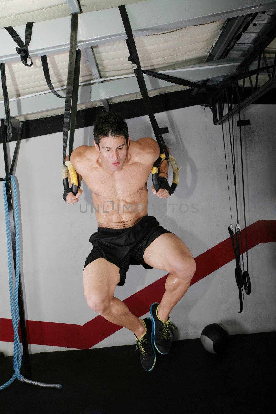 The sportsman the guy, carries out difficult exercise, sports gymnastics. Ring dip Crossfit exercise.