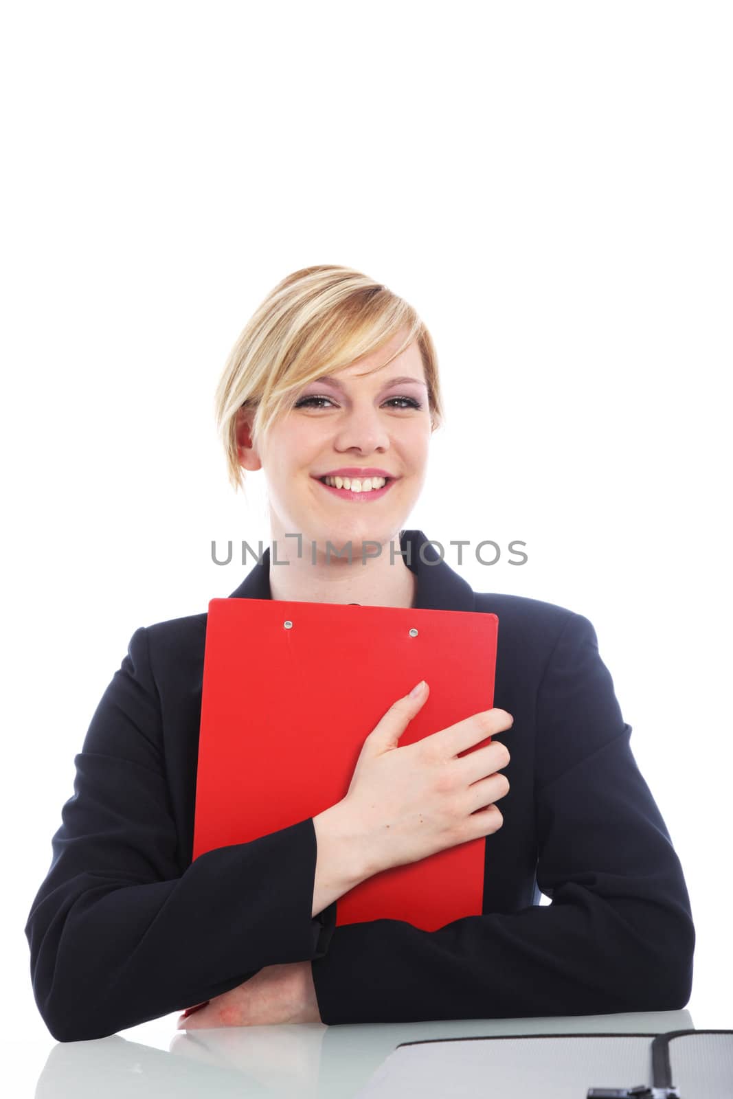Overjoyed young businesswoman with a beaming smile hugging a red clipboard to her chest isolated on white