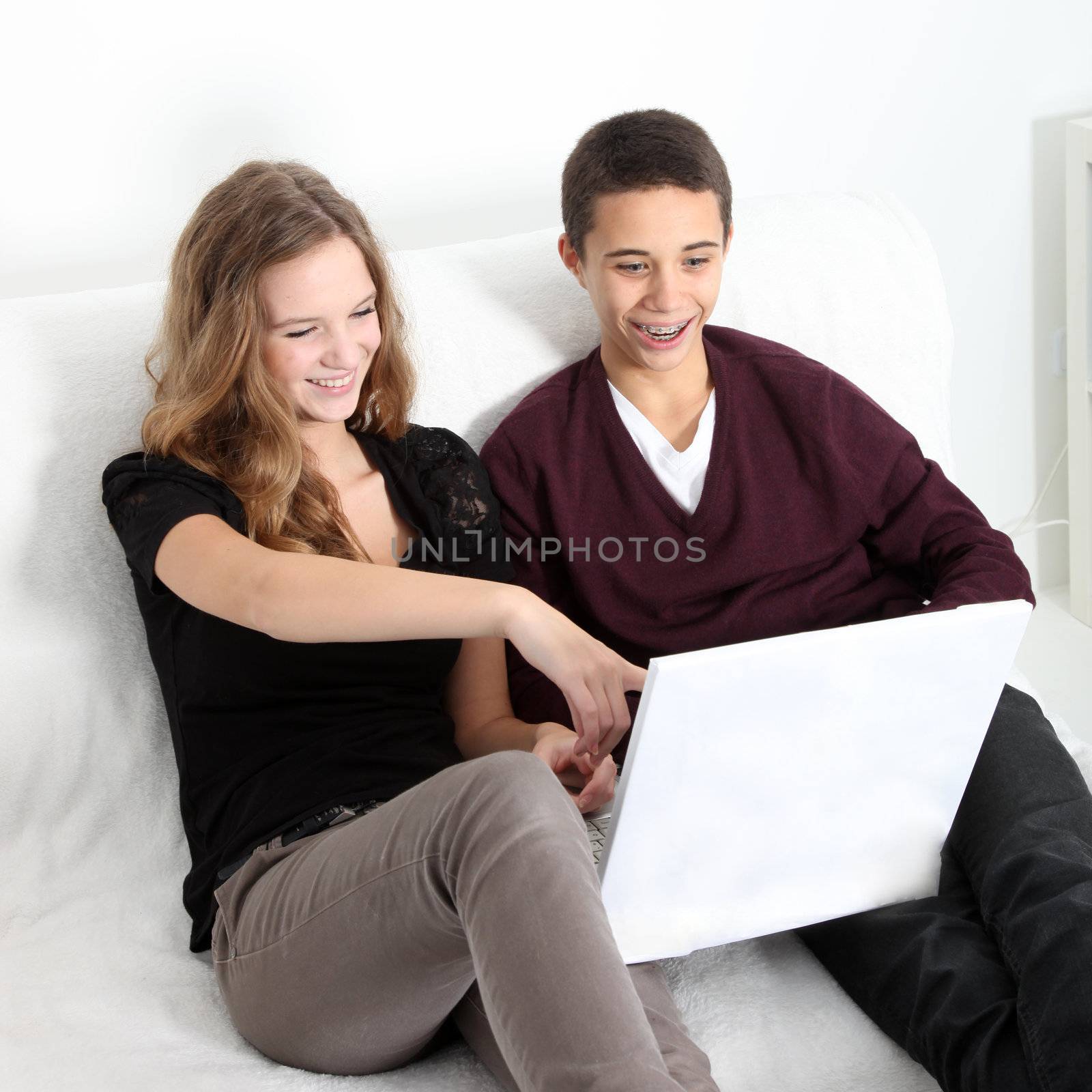 Teenage couple laughing at their laptop Teenage couple laughing at their laptop by Farina6000