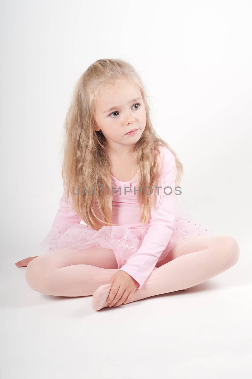 Studio shot of ballet dancer sitting on the floor