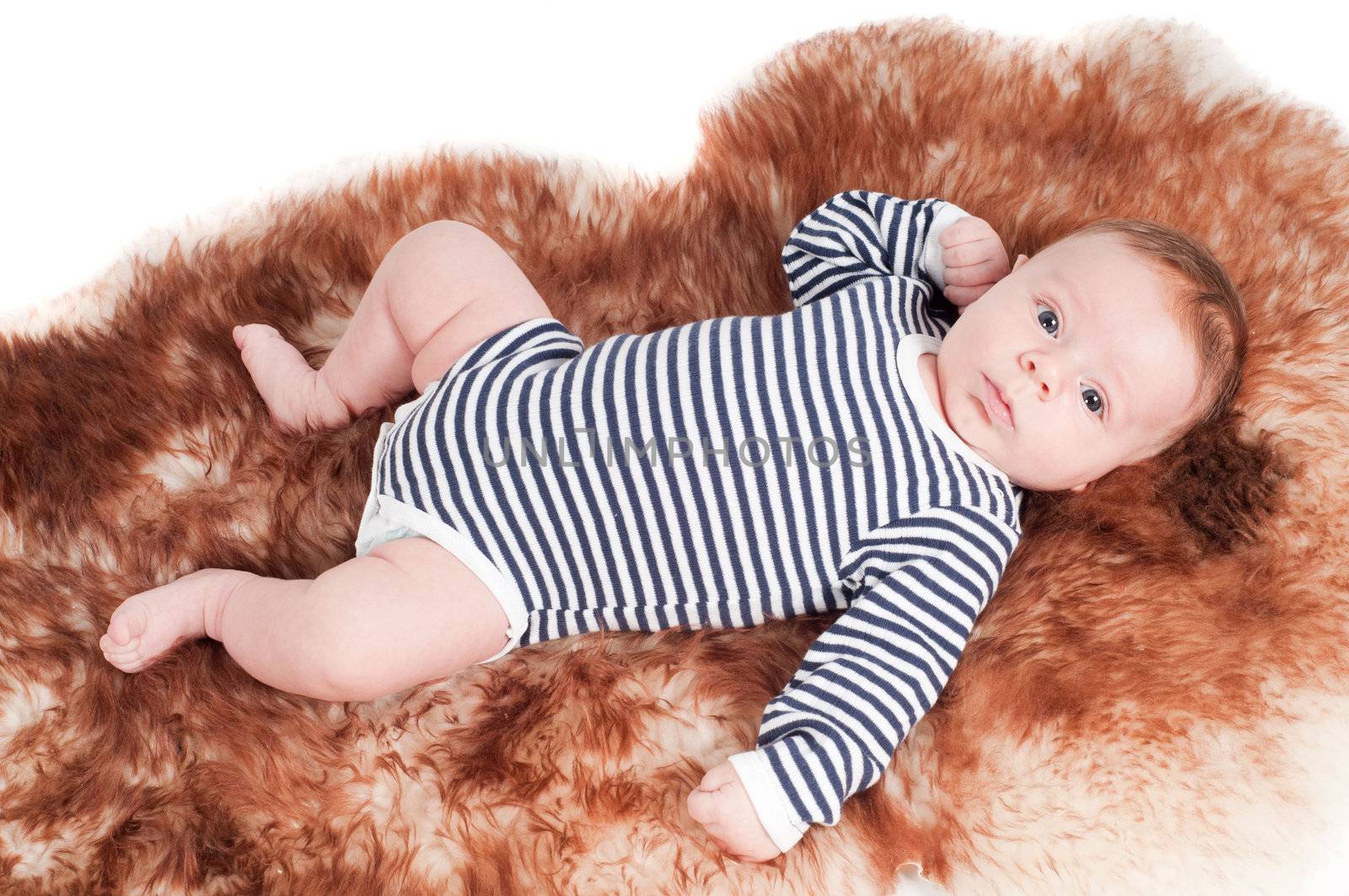 Newborn baby in striped body lying on fur