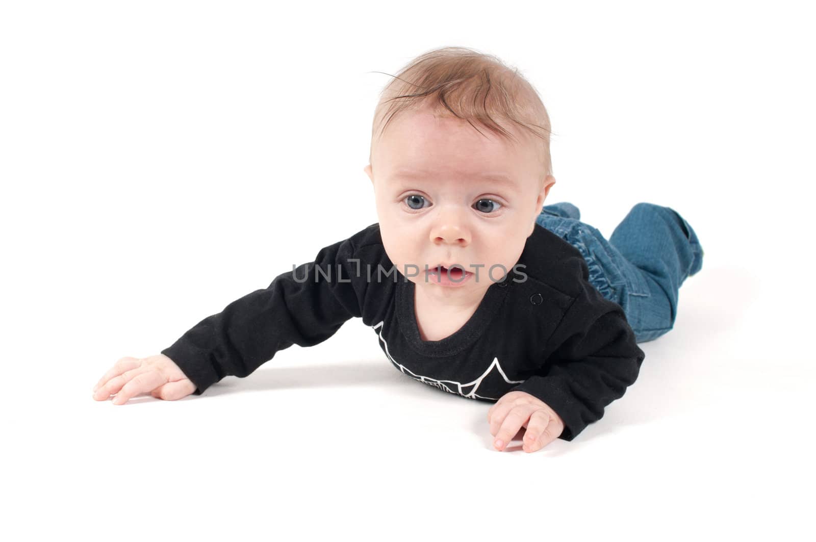 Little baby in jeans and black top lying on white background