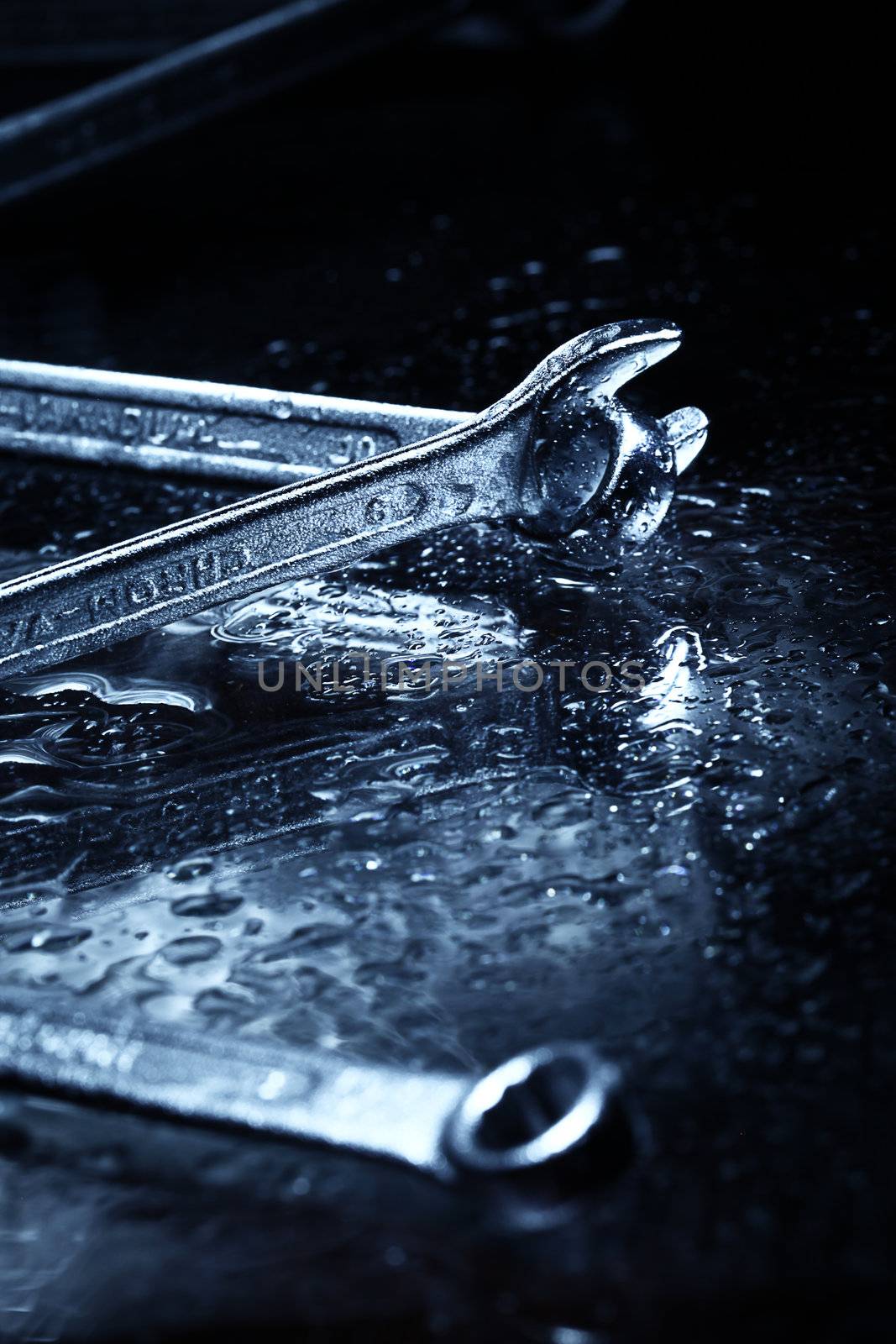 Closeup of iron spanners set over dark light in studio