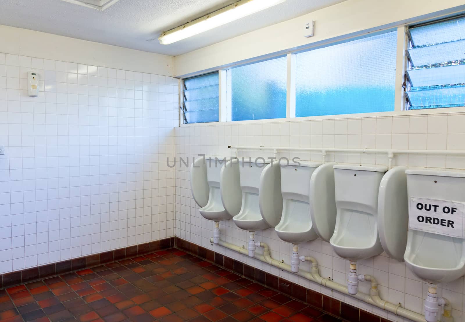 Empty public lavatory with urinal out of order