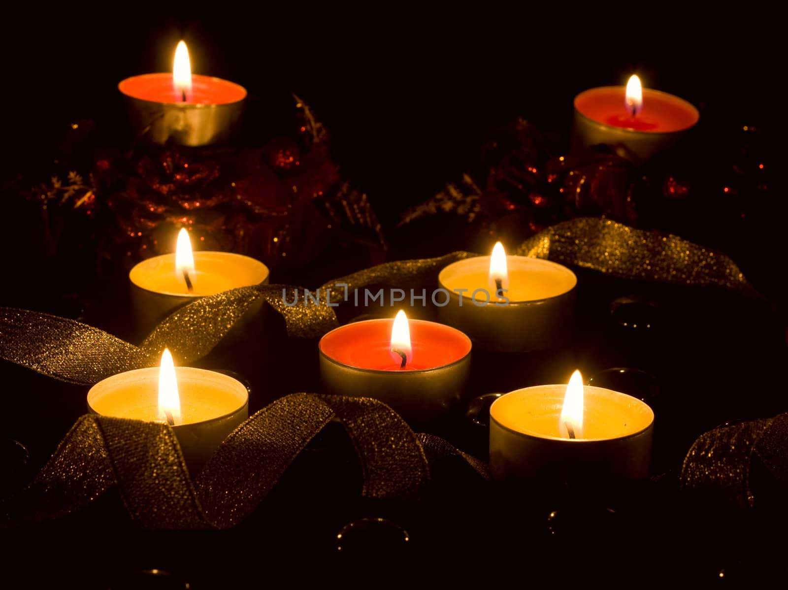 Christmas theme, lights, candles and toys for decoration on a black background.
