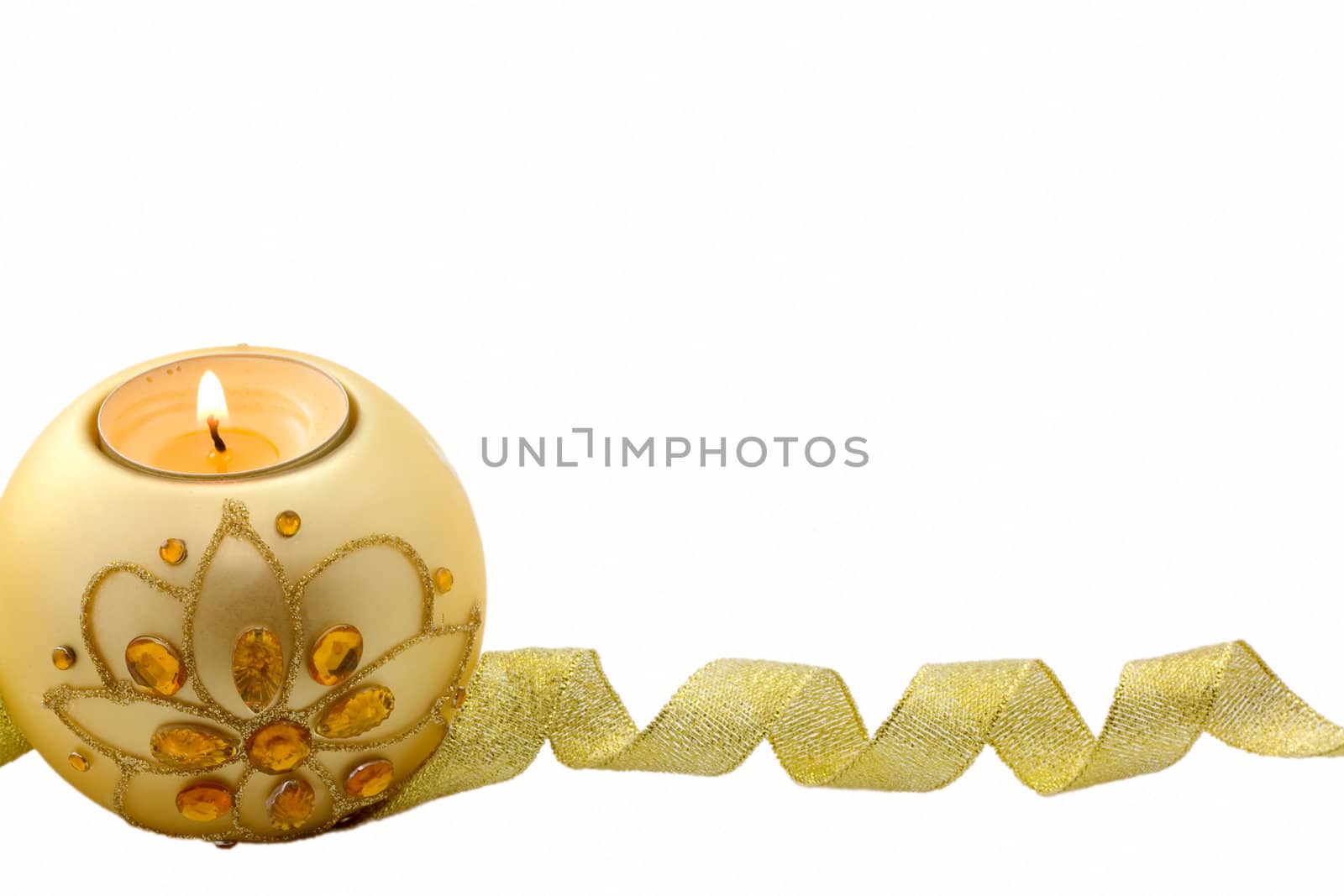 Candle with Christmas decorations and a golden ribbon at the bottom, on white background
