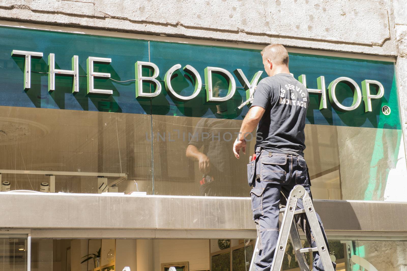 Copenhagen.Denmark -August 2012. The worker installs outdoor advertizing of cosmetic shop.