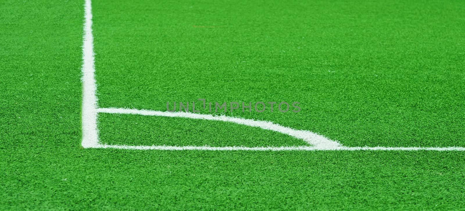 Corner of a football (soccer) field is made from synthetic lawn
