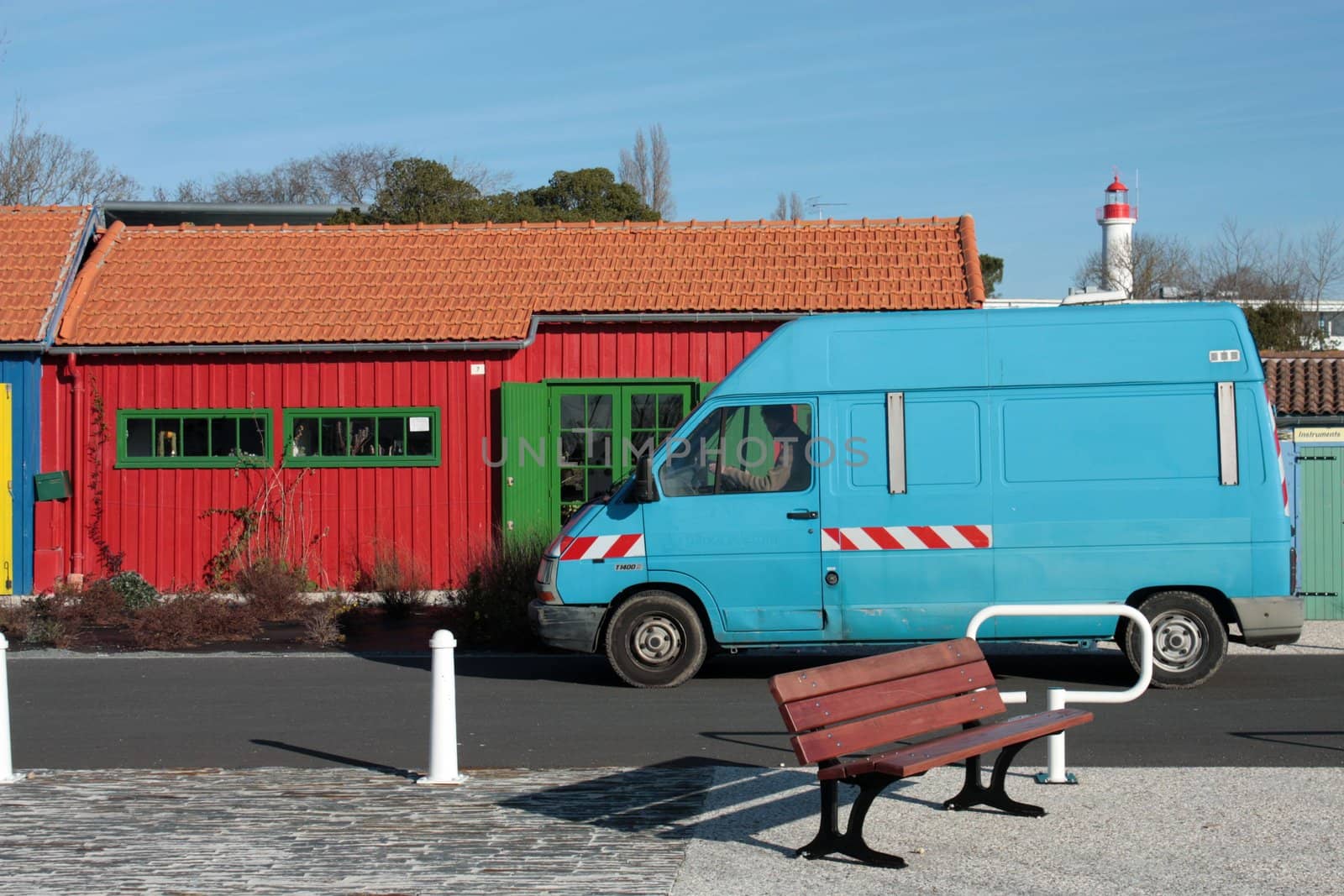 blue car with red island house and bench on ile d'Oleron, France