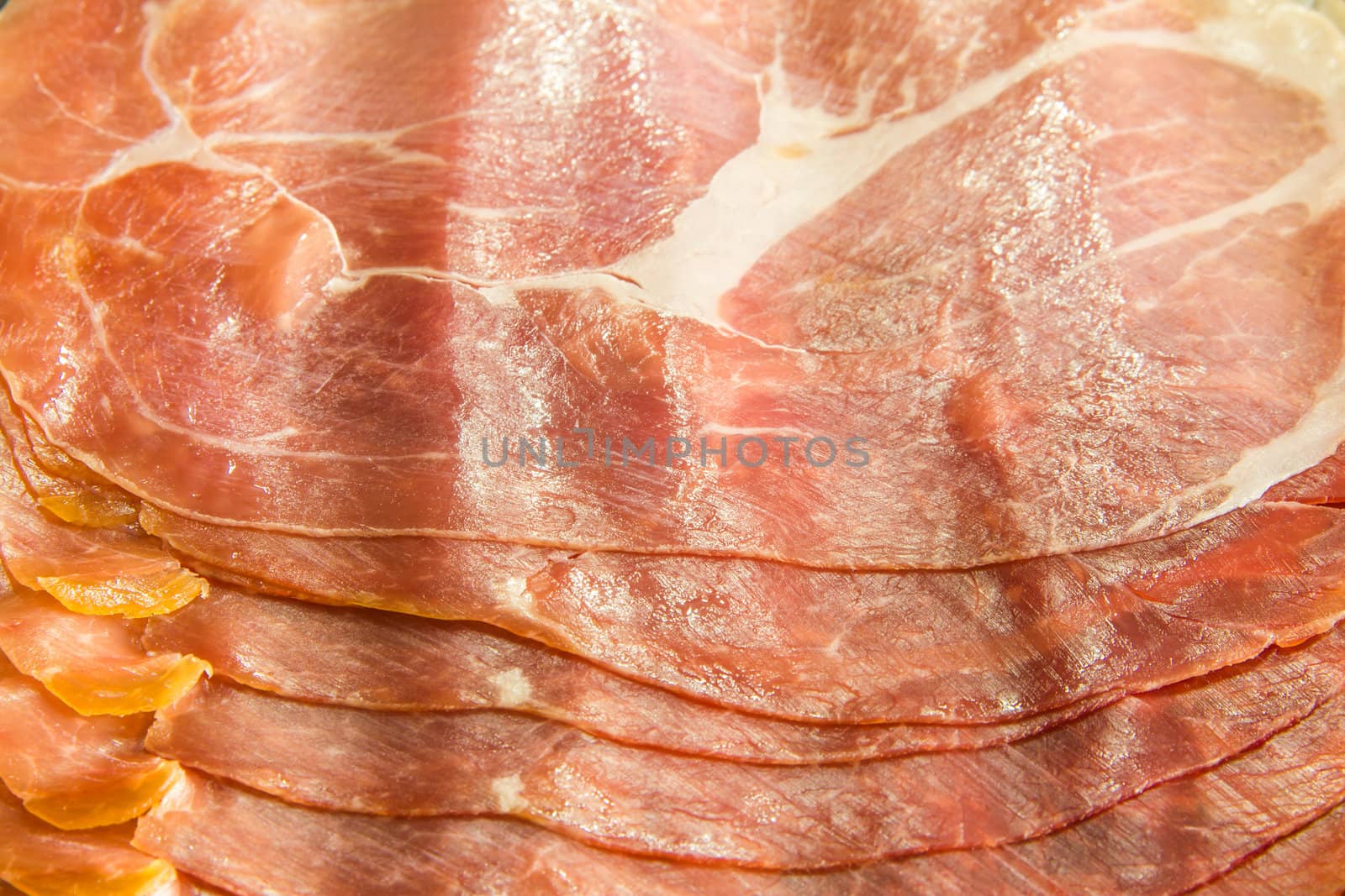 Cured Italian ham prosciutto slices background by huntz