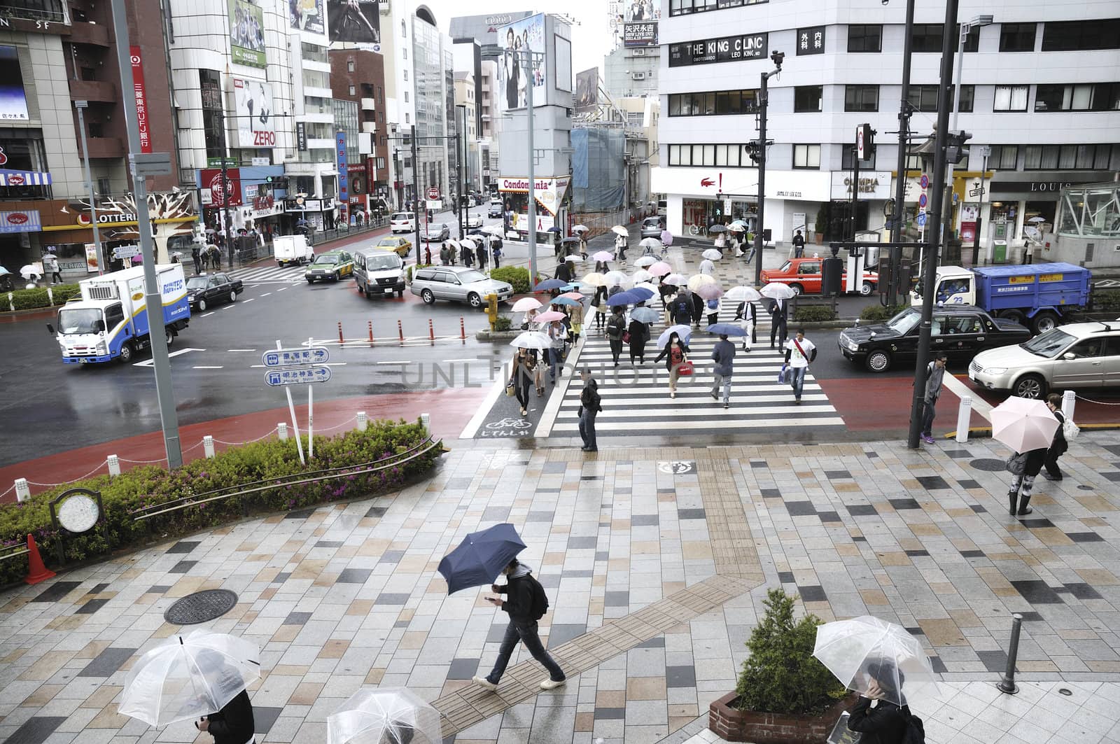 Tokyo, Japan -April 23, 2011 : people crowd cross over street in Tokyo Omote-sando area under rain. 
