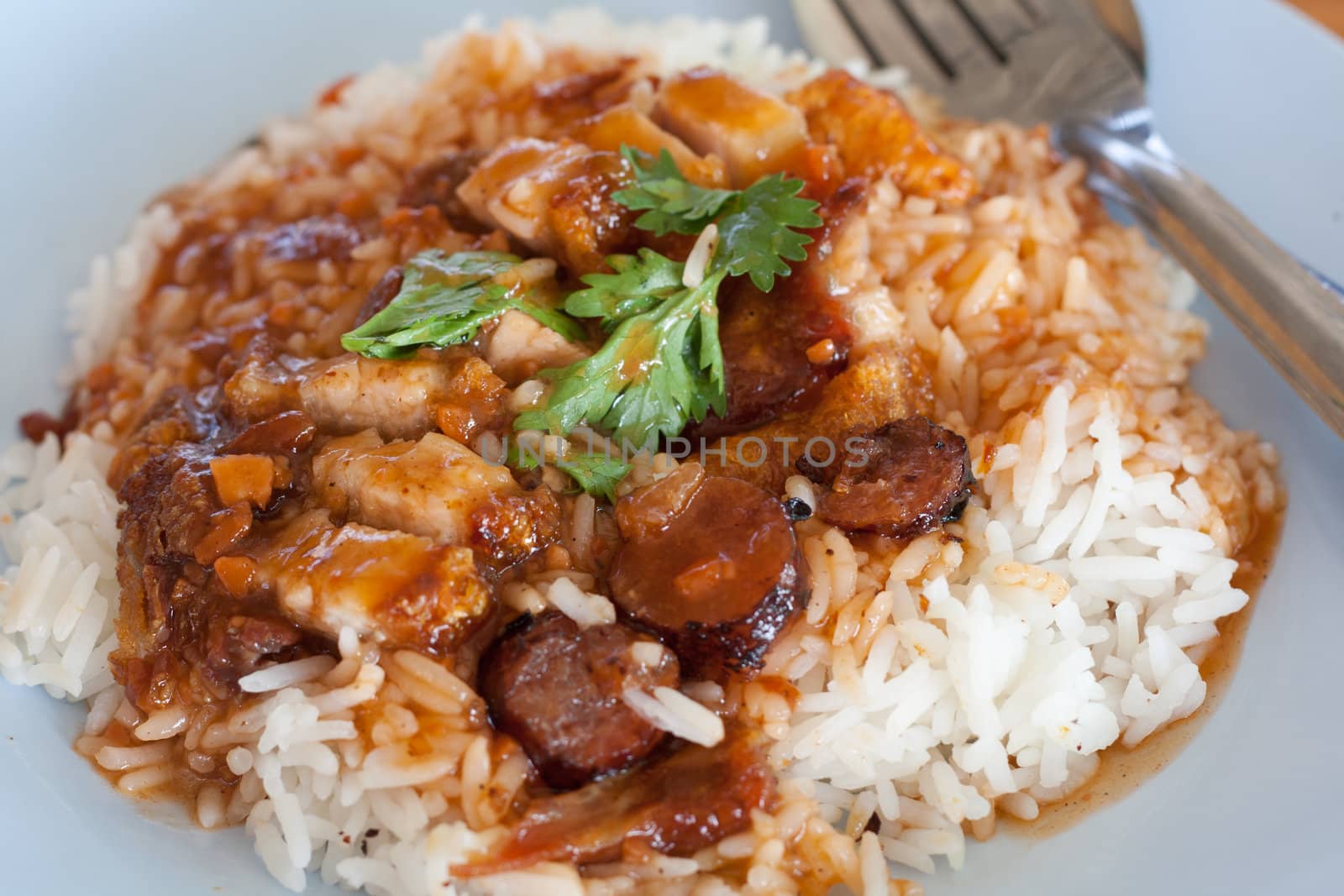 Rick with pork crispy and sausage served with red soup.