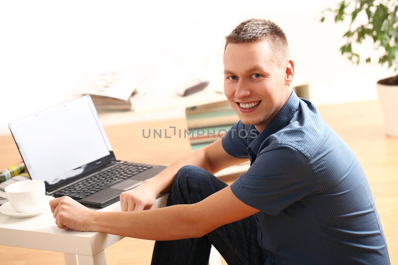 Young and happy guy with laptop relaxing at home