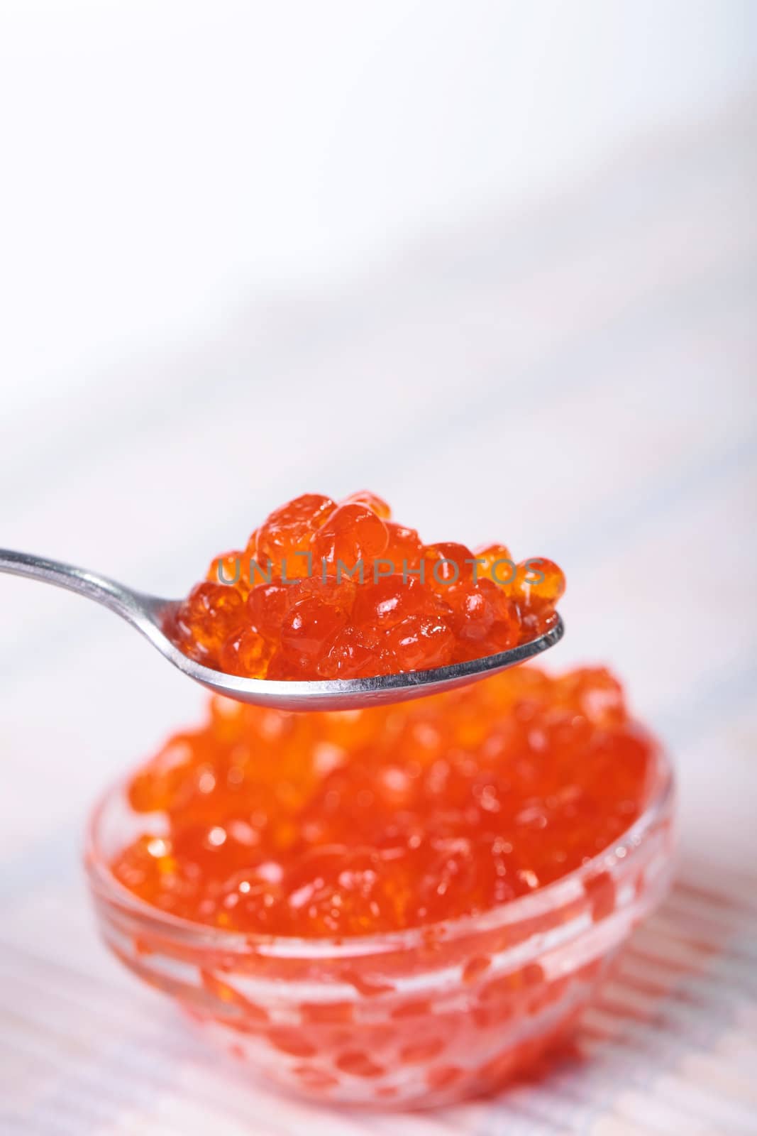 Close up of red tasty caviar in a glass jar with spoon