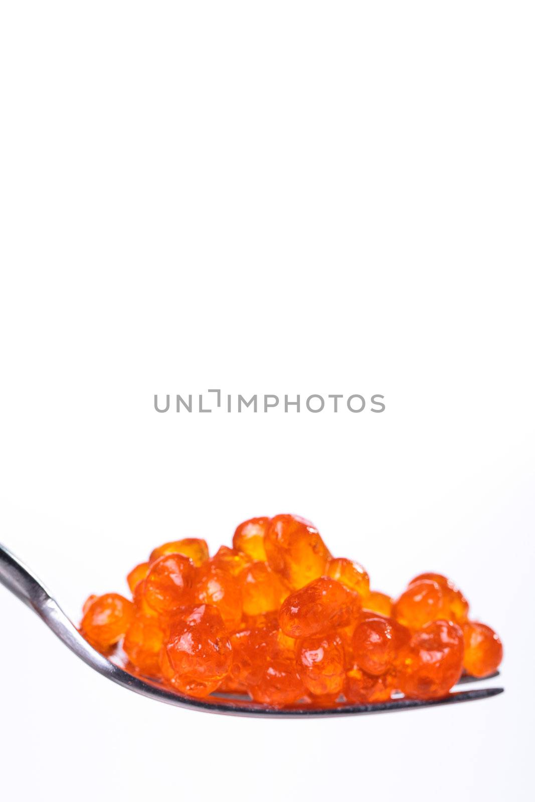 Close up of red tasty caviar in a spoon over a white background