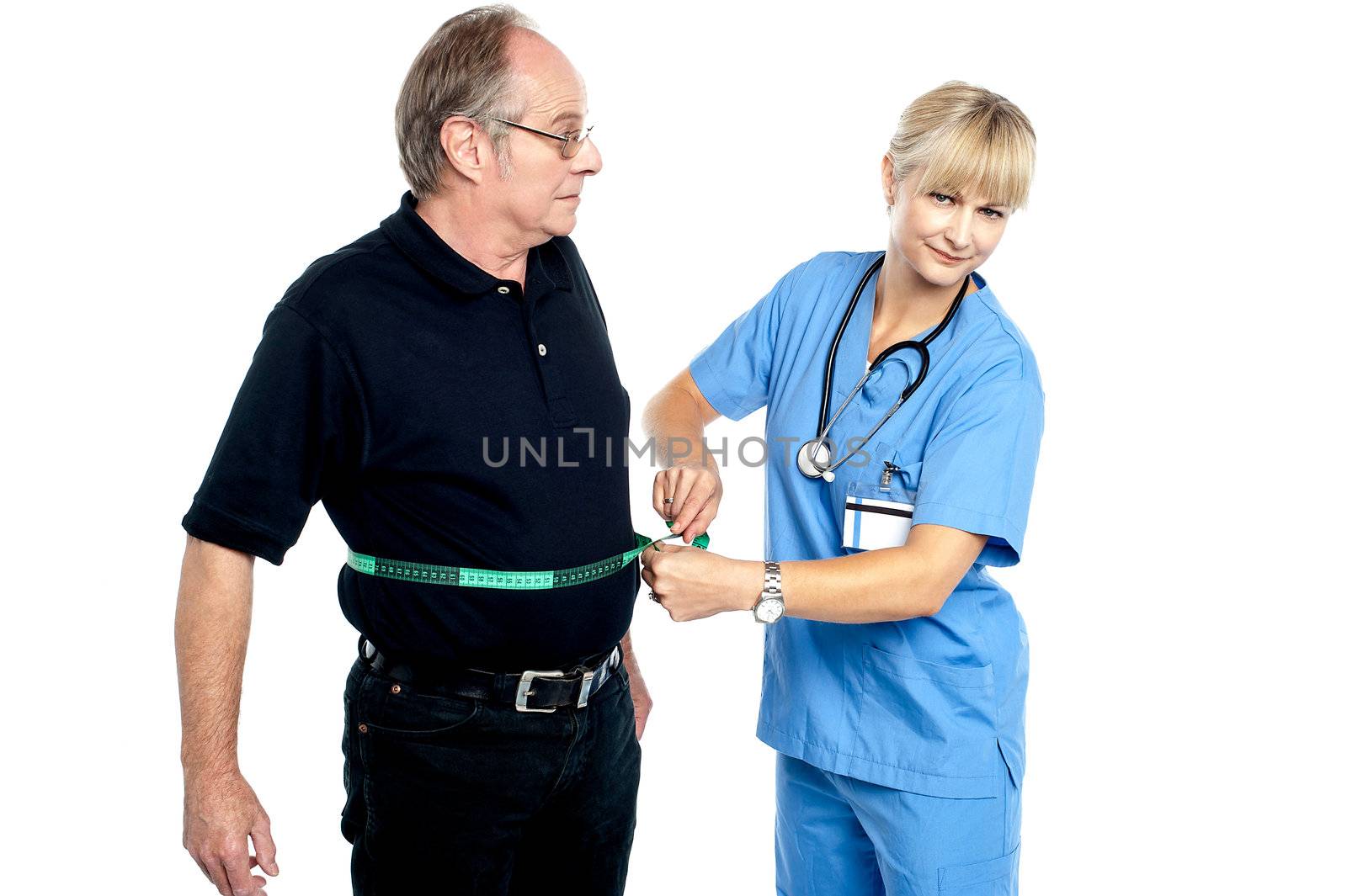 Pretty female doctor measuring waist of senior surprised man.