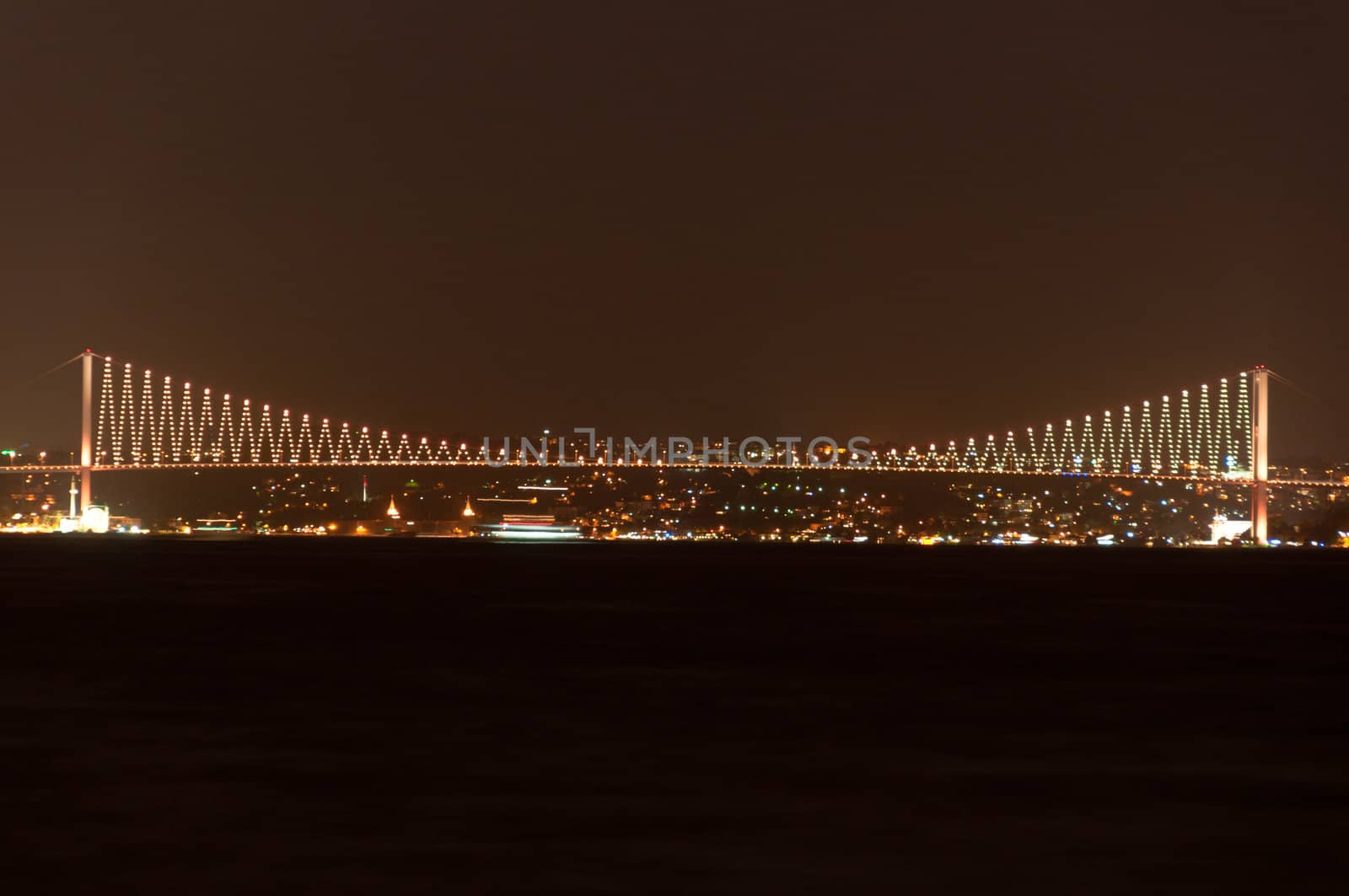 Illuminated Bosporus Bridge at night in Istanbul, Turkey