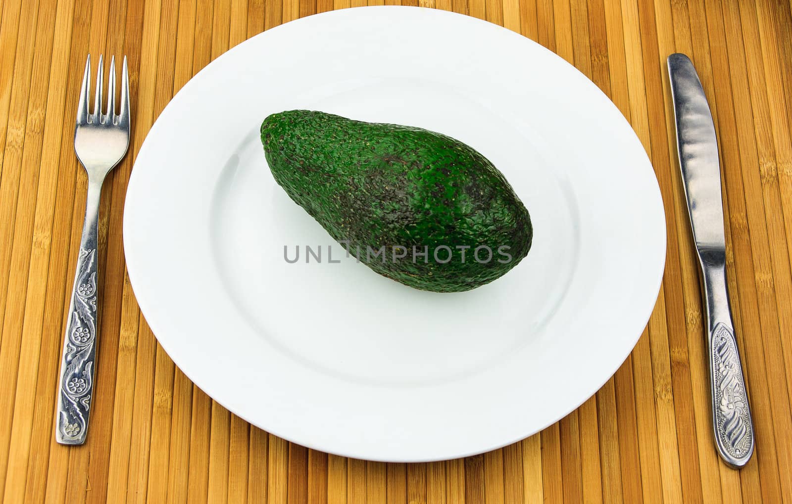 avocado on a plate with cutlery by sfinks