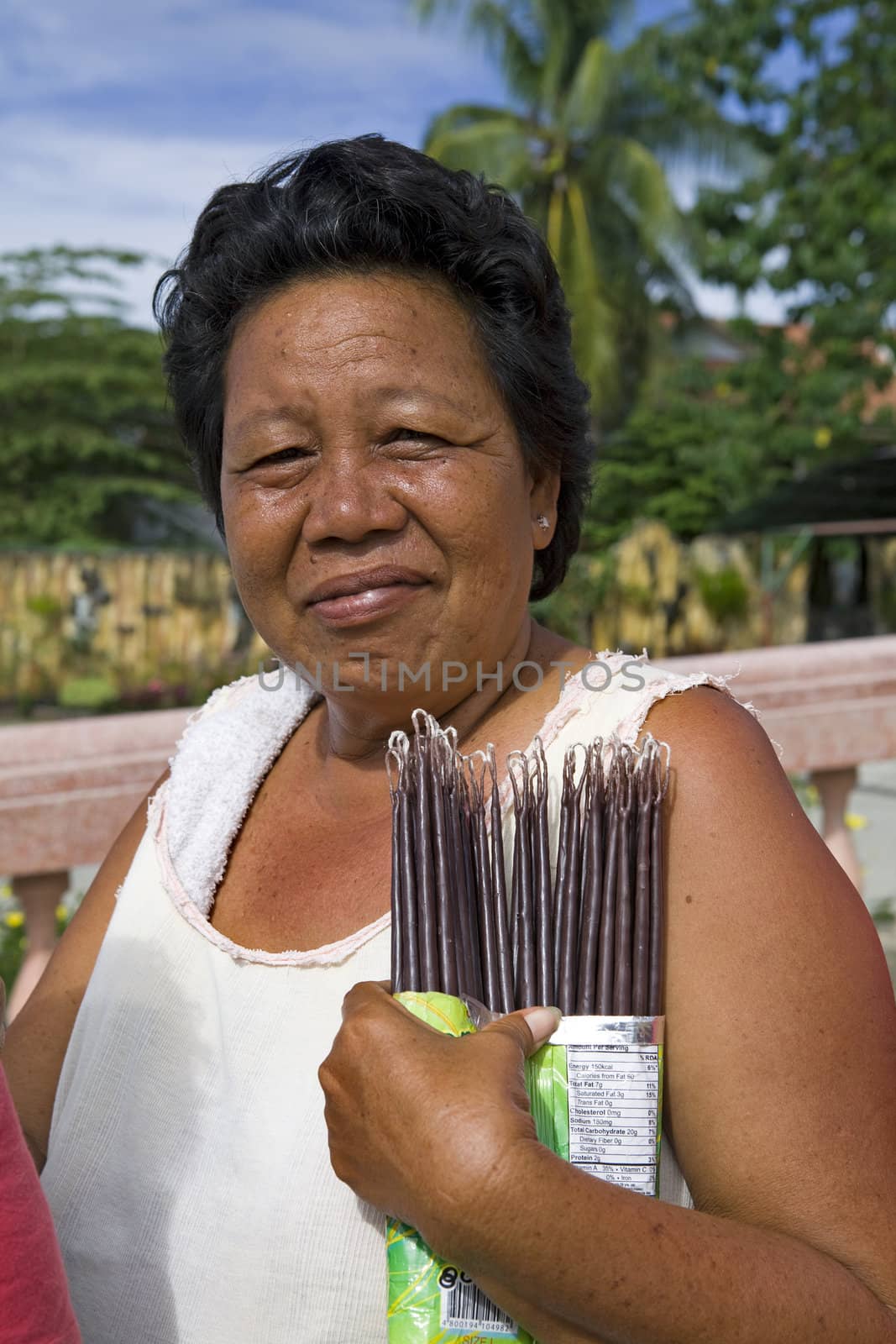 May 2012 - Bogo City, Cebu Island, Philippines - Middle-aged Filipino woman sells votive candles near the Catholic cathedral in Bogo City, Cebu, Philippines.