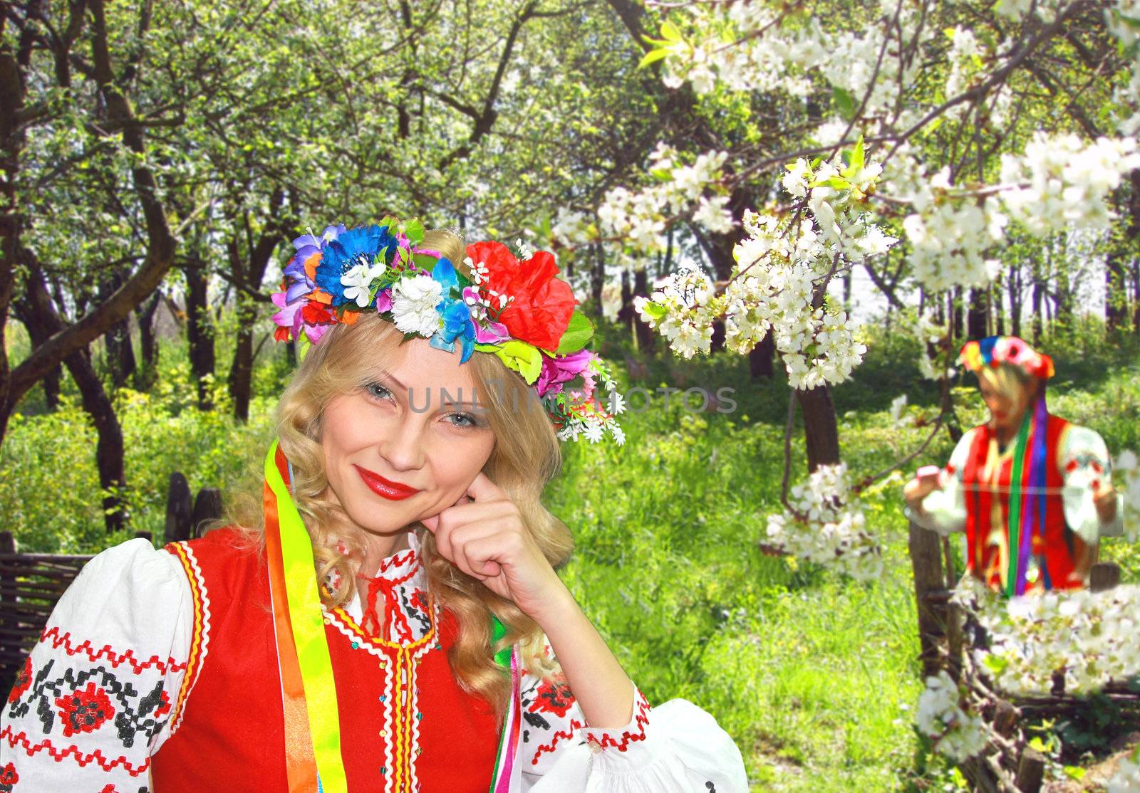 Ukrainian girl in national dress in a flowering spring garden