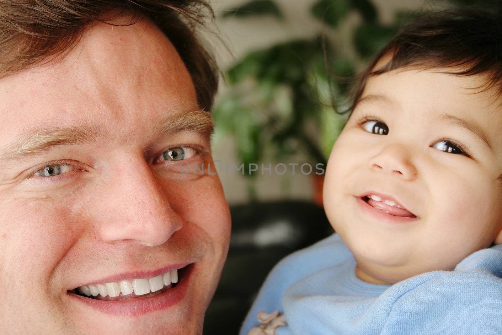 Father and infant son smiling together by jarenwicklund