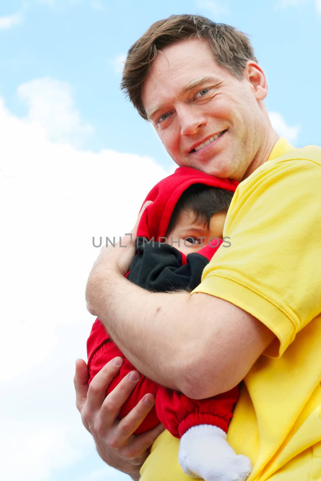 Baby cuddled safely in dad's arms