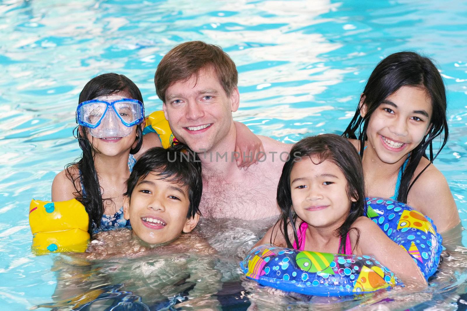 Family swimming in pool by jarenwicklund