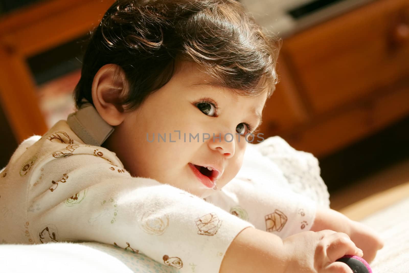 Handsome baby on tummy, part Scandinavian, Thai background