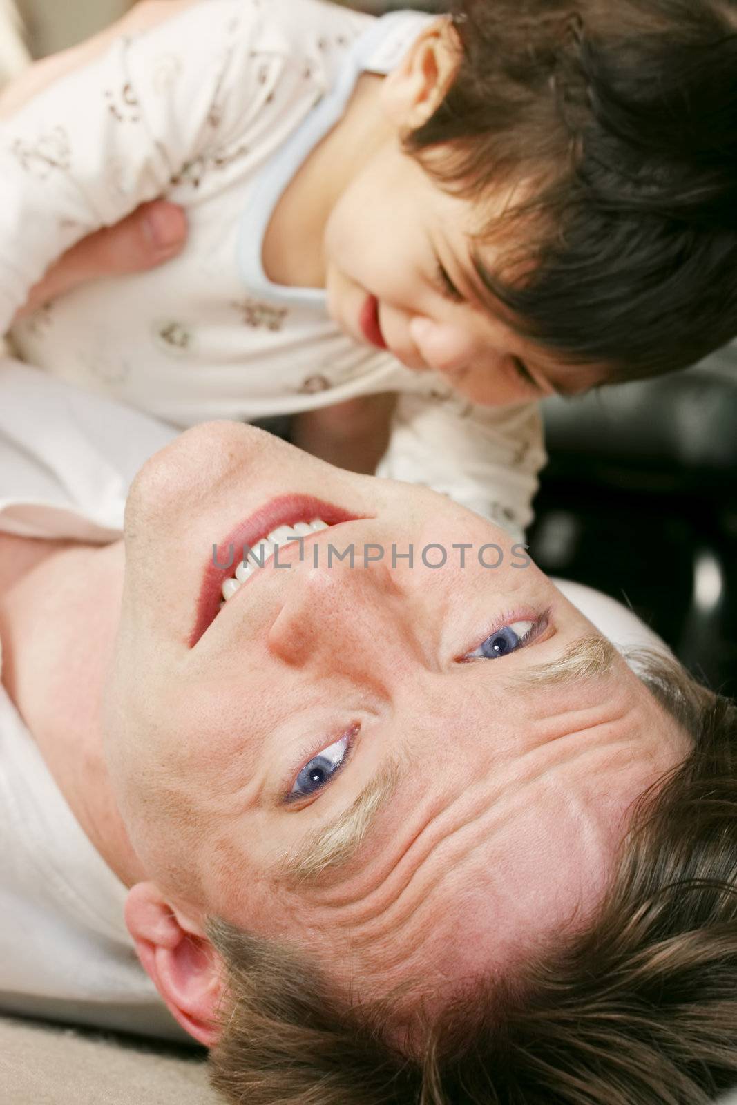 Father playing with baby boy  on floor