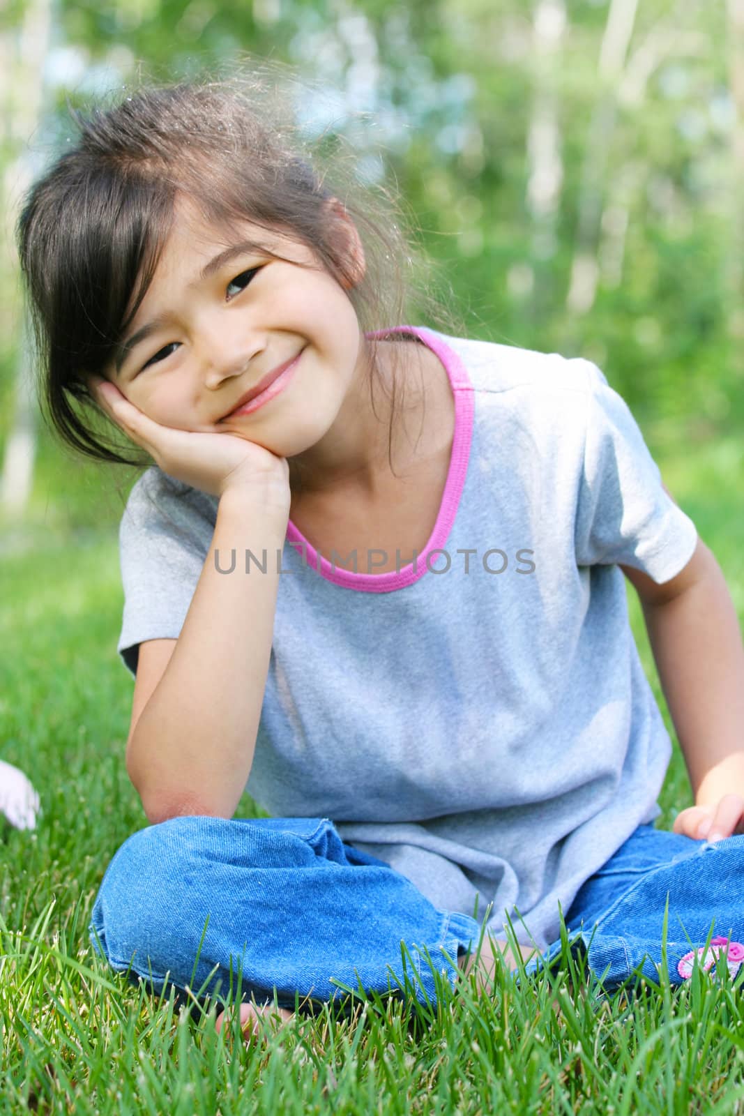 Child sitting on grass with a thoughtful expression. by jarenwicklund