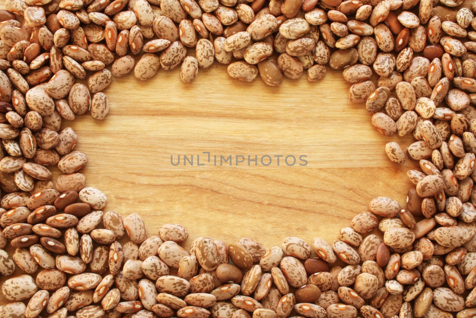 A close-up background or wallpaper image of heirloom dry Pinto beans on a wooden background