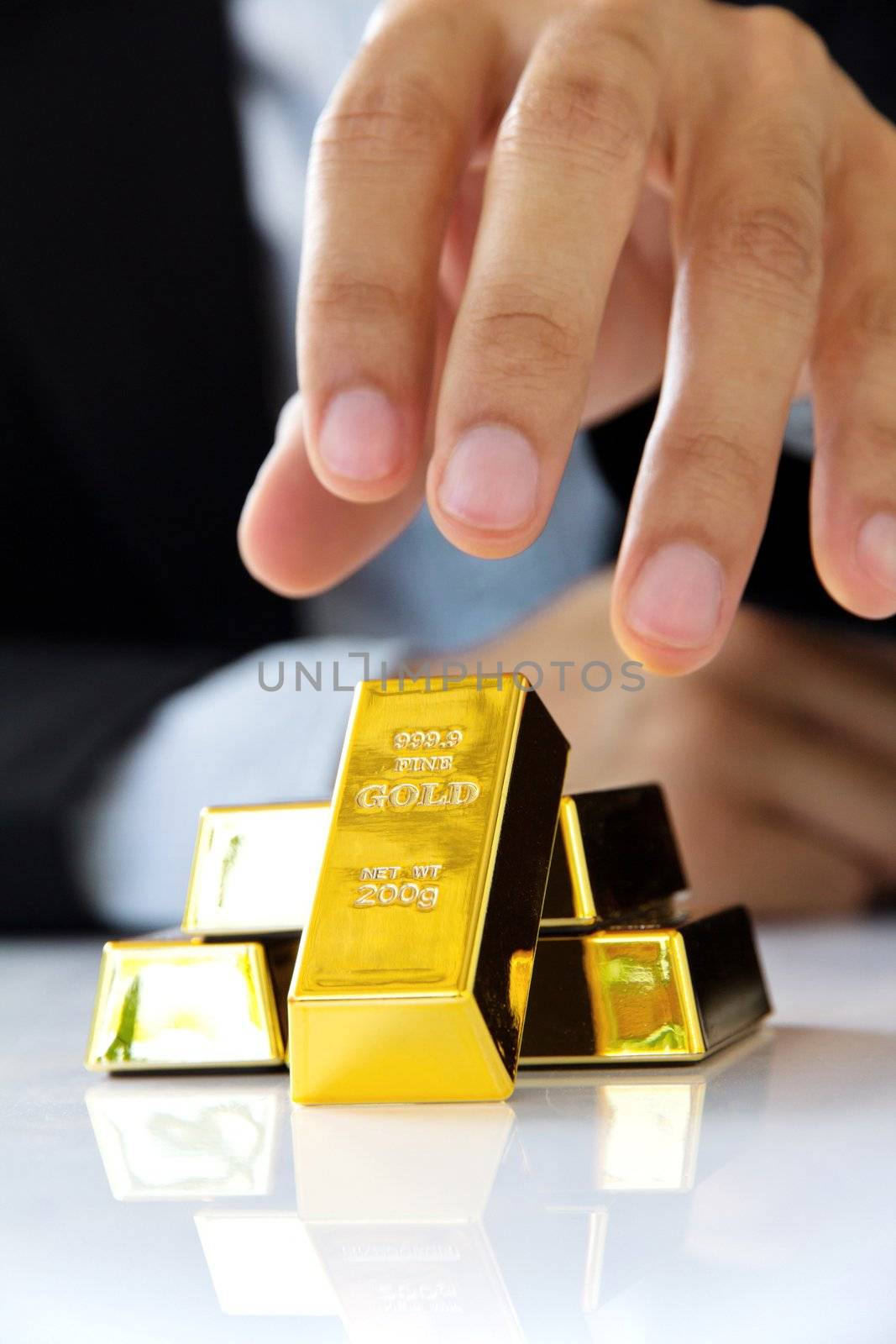 hand holding gold bars by ponsulak