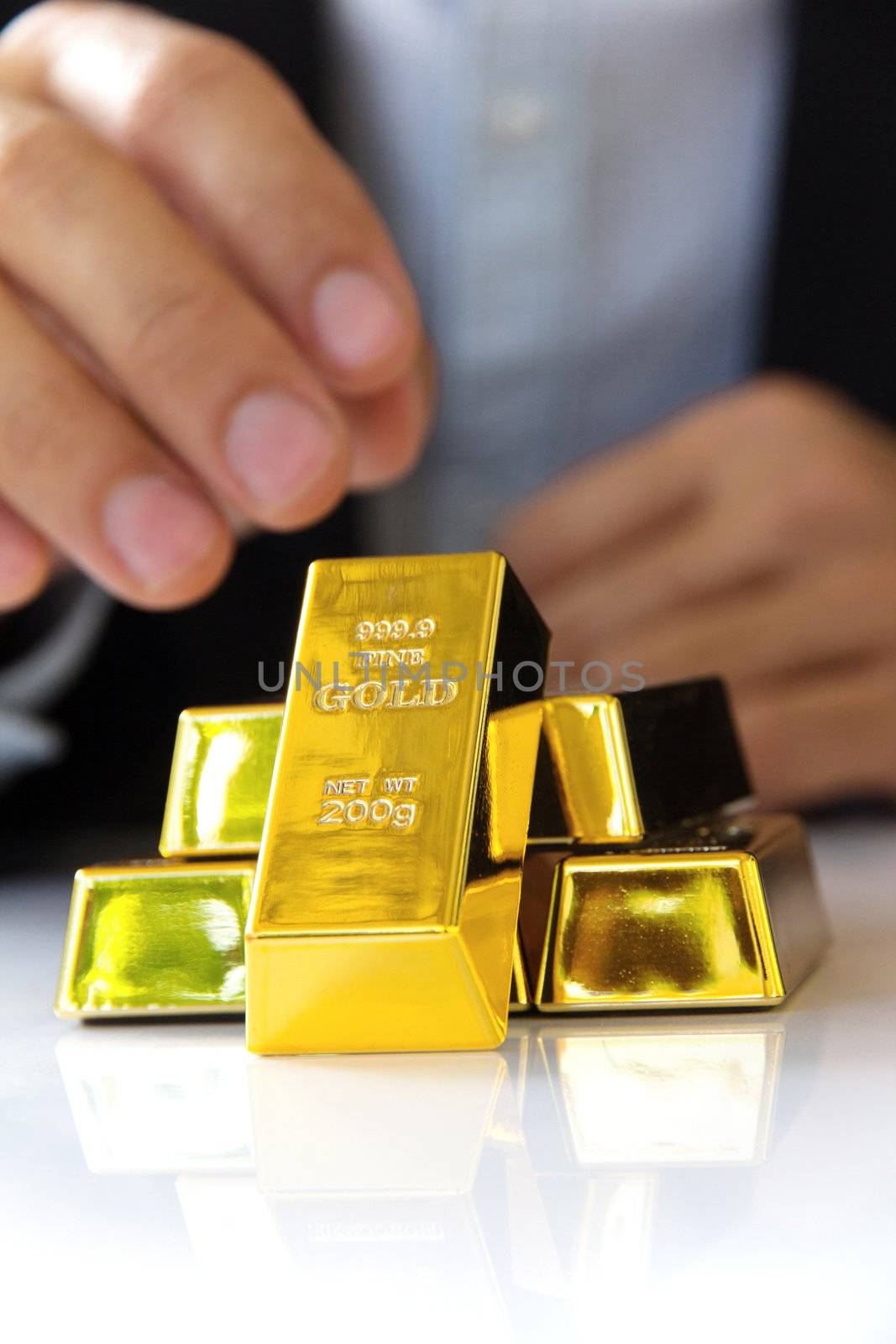 hand holding gold bars by ponsulak