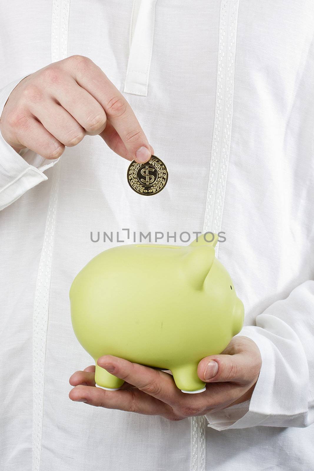 Close-up photograph of a green piggy bank in man's hands.